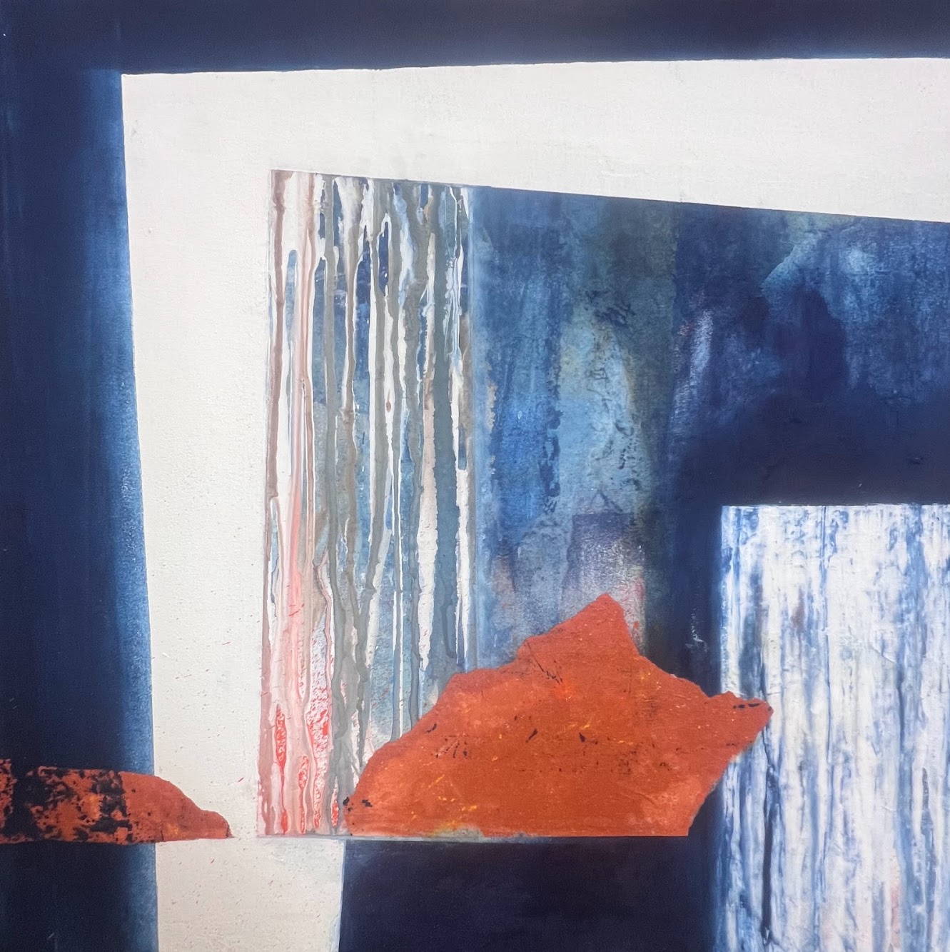 Œuvre abstraite 60x60 en bleu profond avec une forme ocre rouille centrale, marqueterie de papier et pigments naturels.